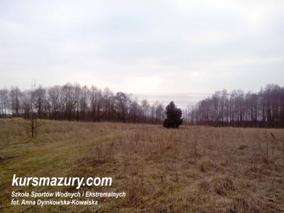 Rozległy widok z łąki na jezioro Śniardwy i okoliczne tereny.